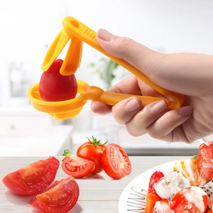 Manual yellow tomato and grape slicer tool for uniform fruit cutting in kitchen