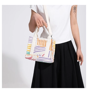 Model wearing a colorful corduroy bag with abstract stripes and dots in a studio setting
