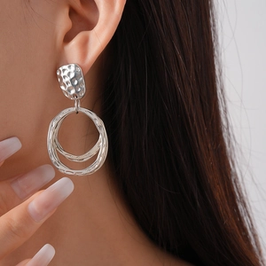 Gros plan de boucles d'oreilles argentées à double anneau martelé sur un mannequin