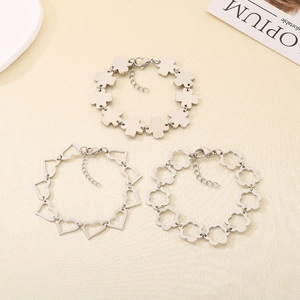 Three silver stainless steel bracelets with hollow clover, heart, and flower charms