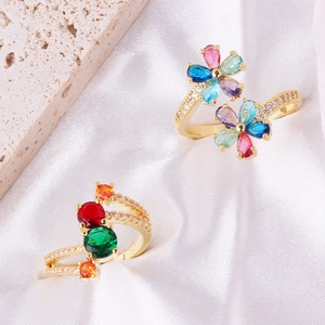 Chic gold-plated flower rings with colorful zirconia stones on white silk backdrop