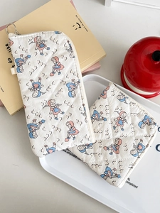Detail of cream quilted cotton storage pouches featuring vintage cartoon girl prints