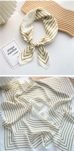 Close-up of pearl white silk scarf with mustard yellow geometric lines and V patterns