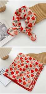 Detail of beige square scarf with red hearts, green dots and delicate lace trim edge