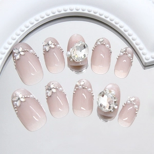 Cat eye press-on nails with pearls and rhinestones on a reflective mirror surface