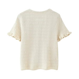 Détail du haut en tricot blanc crème avec manches à volants et texture ajourée crochetée