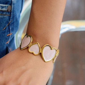 Pink marble heart links bracelet in gold stainless steel finish worn by a model