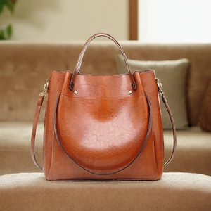 Macro shot of vintage brown oil wax leather tote bag with metallic rivet details