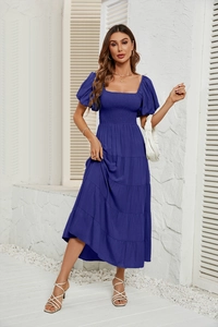 Détail de la robe bleu roi avec manches bouffantes, col carré et jupe à étages