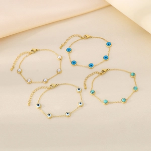 Détail de bracelets dorés avec œil maléfique, perles et turquoise sur soie
