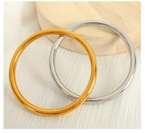 Macro view of gold and silver minimalist bangle bracelets on wooden stand