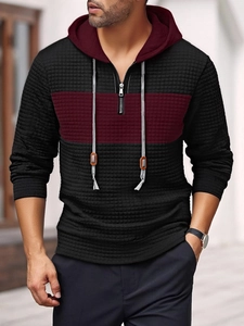 Detail of color-block hoodie with waffle texture, half-zip neckline and gray drawstrings