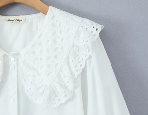 Detail der weißen Bluse mit hohler Stickerei am Puppenkragen und Schulternähten