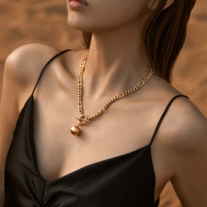 Gold plated chunky chain necklace with OT buckle and metallic ball pendant worn by model
