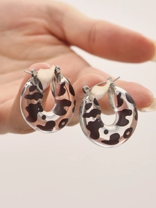 Detailed macro view of U-shaped clear resin earrings with leopard print and silver posts