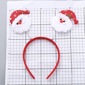 Christmas headband with spring Santa Claus figures shown against a measuring scale for size