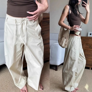 Detail of beige drawstring cargo pants featuring a retro loose fit and cotton texture