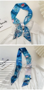 Detail of oil painting style silk scarf used as a necktie and laid out on a table