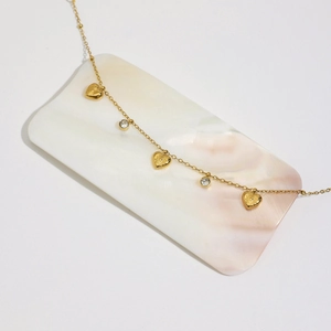 Detail of 18K gold-plated stainless steel bracelet with heart charms and zircon inlay