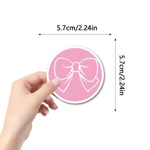 Pink Coquette Bow sticker in 5.7cm diameter held by hand for scale on white background