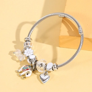 Detail of silver wire bracelet with enamel elephant, heart charm and faceted crystals