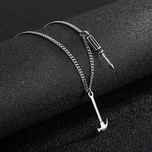 Detailed macro view of silver hammer and screwdriver tool pendants on a metal chain