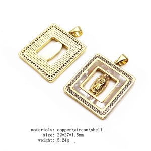 Detail of square gold religious pendant showing copper and shell texture with zircon inlay