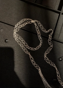 Detailed view of flexible multi-strand woven mesh necklace in metallic gold finish