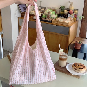 Detail of pink and white checkered canvas tote bag with lightweight pleated fabric texture