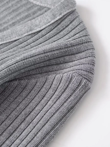 Close-up of grey ribbed knit texture and stitching detail on a soft V-neck sweater