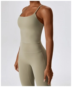 Detail of sage green yoga bodysuit showing fine spaghetti straps and waist seam stitching