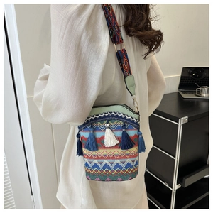 Dettaglio della borsa a secchiello boho con nappe colorate e tracolla tessuta etnica