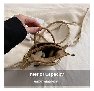 Detail view of khaki mini bucket bag interior capacity with drawstring and woven handle