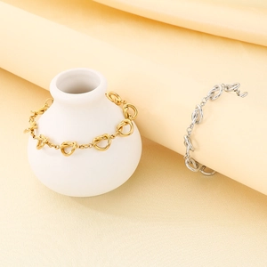 Gros plan de bracelets à nœuds en or et argent sur un fond de tissu neutre élégant