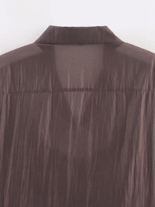 Detailed view of coffee brown blouse with semi-transparent silk-like fabric texture