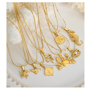 Close-up of gold-plated animal pendants like snake, bird, and crab on various chains