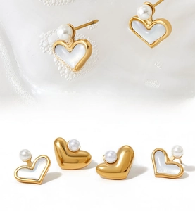 Dettagli macro di orecchini a cuore in acciaio inossidabile dorato con perle e conchiglia