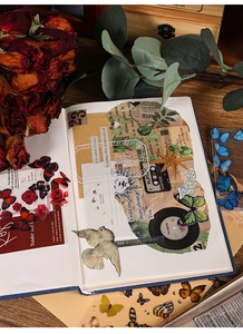 Detail of vintage scrapbook stickers with butterfly and floral motifs on dark wood