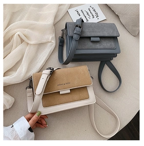 Detail view of two-tone flap shoulder bags with chic suede textures and metallic clasps