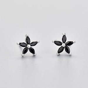 Detail shot of five-petal flower stud earrings with black cubic zirconia in silver setting