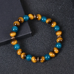 Close-up of beaded bracelet with tiger eye stones and blue crystals on jewelry box