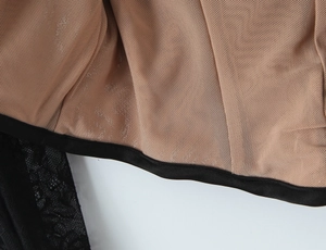 Detailed close-up of beige mesh lining fabric with black trimmed edges and fine texture