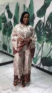 Detail of silk-like floral print two-piece set featuring wide sleeves and high-waisted pants