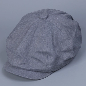 Detailed close-up of blue grey vintage newsboy cap fabric with top button and stitched panels