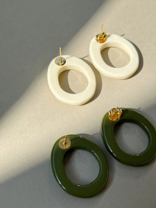 Detailed view of resin geometric earrings with gold-tone backing and CELINE PARIS engraving