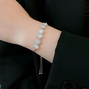 Dettaglio del bracciale con fiocco in zirconi su polso con blazer nero elegante