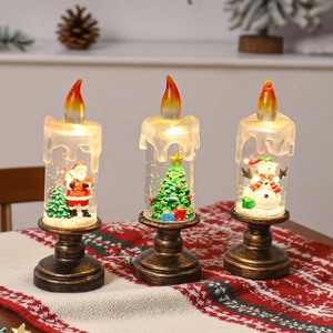 Détail de trois bougies LED de Noël avec figurines Père Noël, sapin et bonhomme de neige