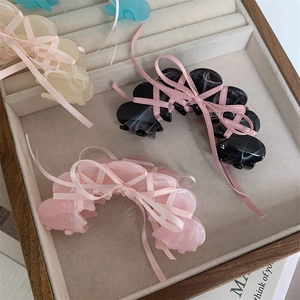Close-up of ballet style acetate hair claws with pink silk ribbons in a jewelry tray