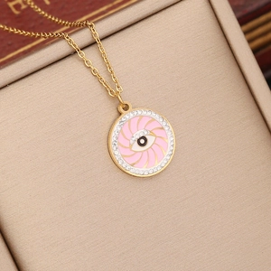 Gold evil eye necklace with pink enamel and crystals in a beige jewelry gift box