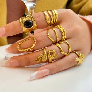 Detail shot of 18K gold plated multi-layer snake and gemstone rings on model hand